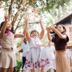 young girls enjoying themselves at a wedding - jumping for confetti