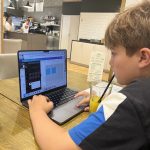 teen drinking juice and working on laptop - copyright realparent.co.uk